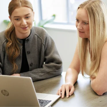 Two colleagues looking at a laptop
