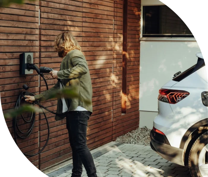 A driver charging an electric car at home.
