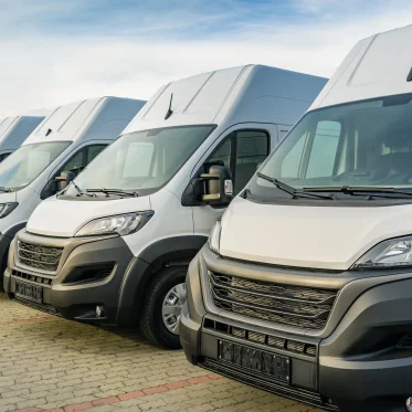 Row of white fleet vans parked together